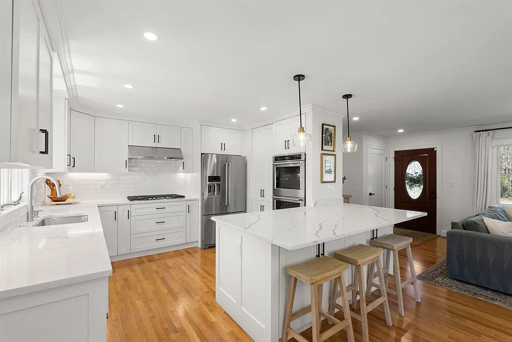 White kitchen with a marble island in the Amesbury home