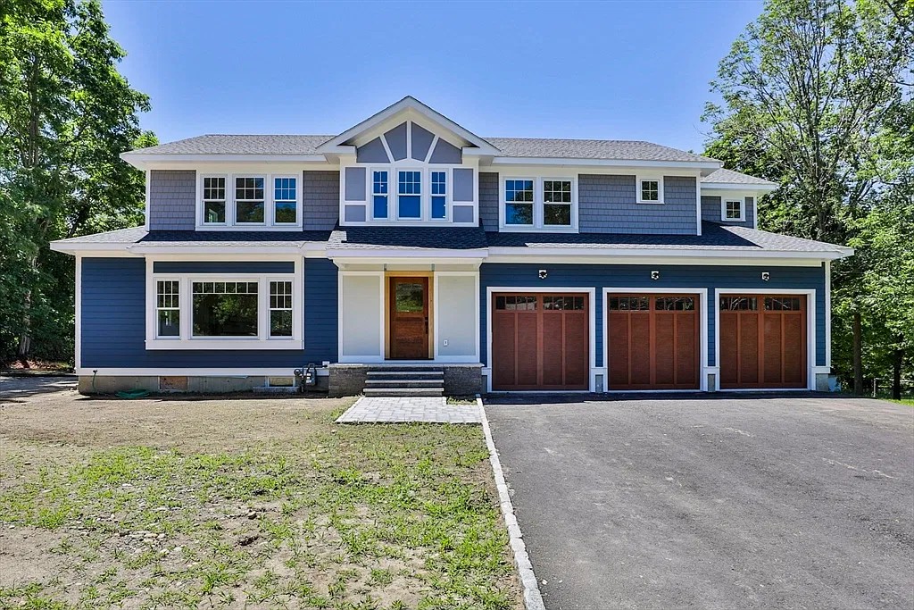 Blue-gray custom home with a wood front door and three-car garage in Amesbury, Massachusetts