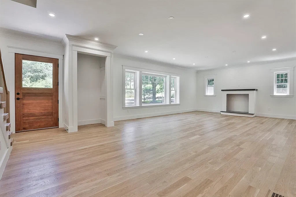 Living room with a fireplace and wood door in the Amesbury home