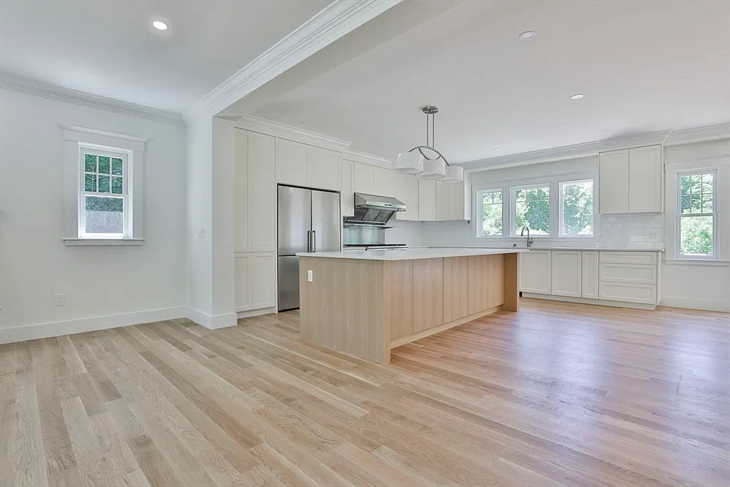 White kitchen with a wood island in the Amesbury home