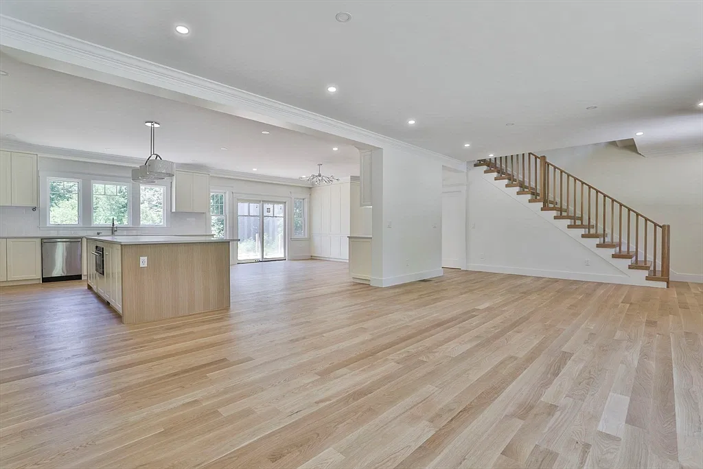Open kitchen and living area with a wood staircase in the Amesbury home