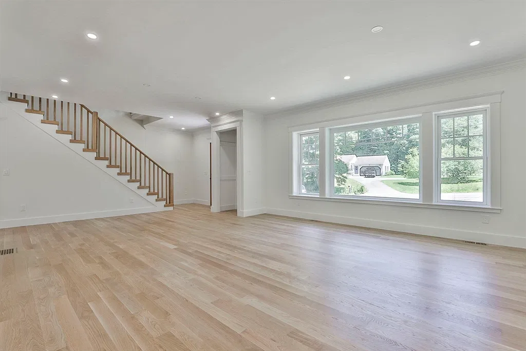 Room with a wood staircase and windows in the Amesbury home