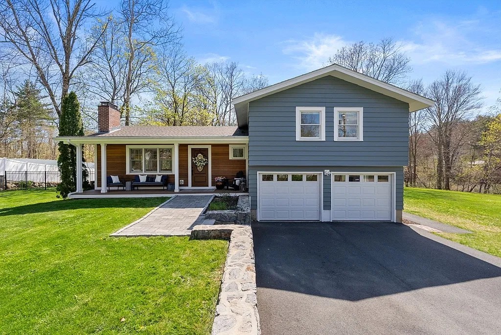 Gray custom home with a wood porch and two-car garage in Amesbury, Massachusetts