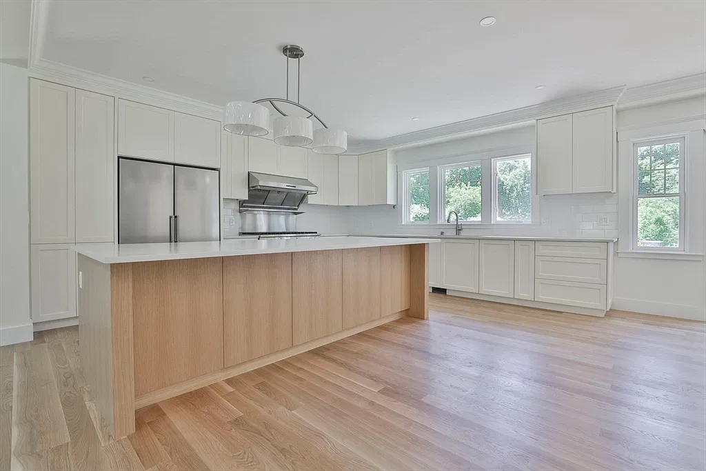 White kitchen with a wood island and stainless appliances